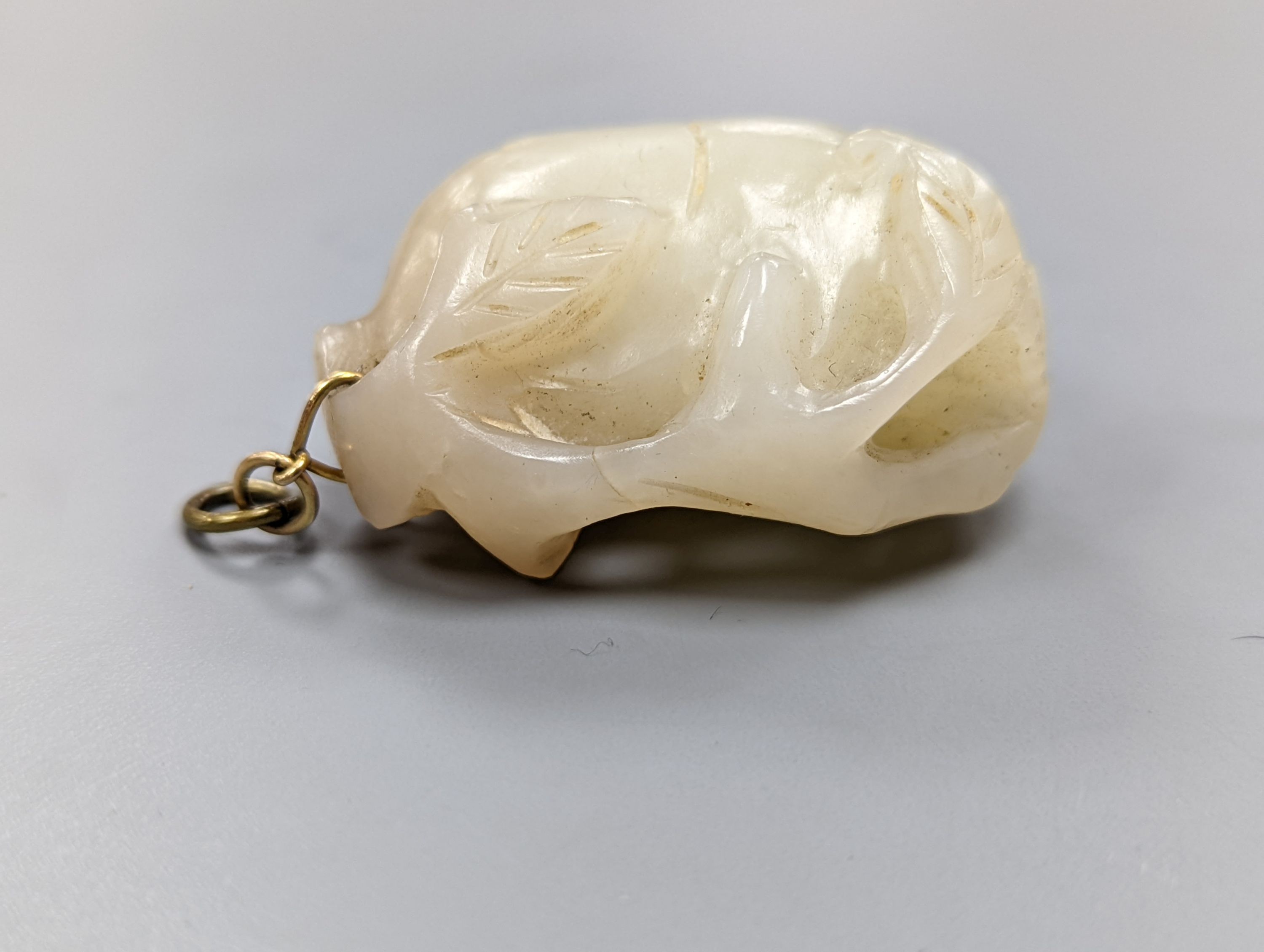 A Chinese whiteish grey jade carving of a peach branch sprig, 19th century, 4.2cm